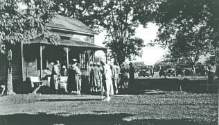 A gathering of village residents at the Clubhouse. Note the vintage automobiles parked nearby!